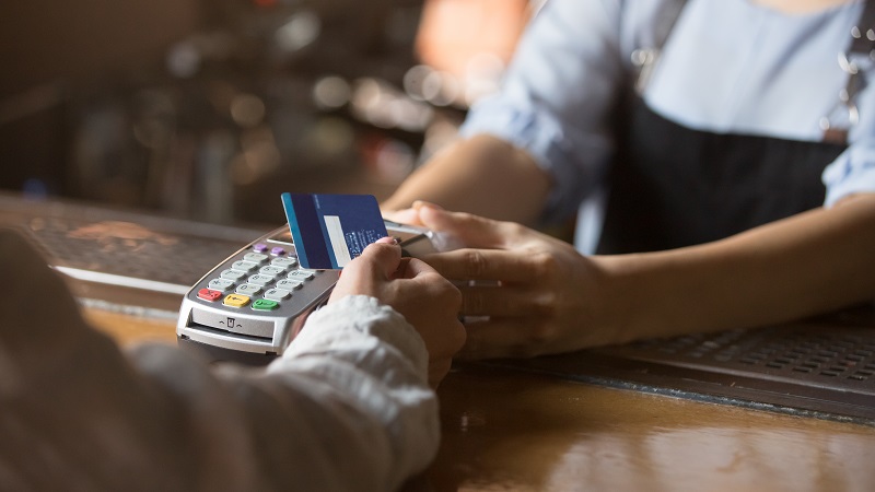 Female ustomer holding cash card for contactless payment